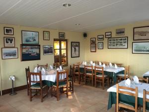 佩德勒纳hotel la trainera的用餐室配有桌椅,墙上挂有图片