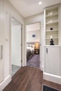 伦敦Beautiful Chelsea Apartment in Fashion District的一间卧室配有一张床,一扇门通往房间
