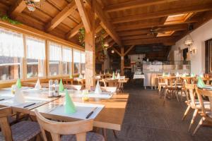 维尔德豪斯舍瑙酒店及餐厅的餐厅设有木桌、椅子和窗户。
