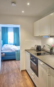 汉诺威Airport & Messe Apartments的一间设有厨房和一张位于客房内的床的房间