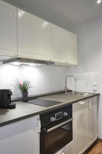 汉诺威Airport & Messe Apartments的厨房配有白色橱柜和水槽
