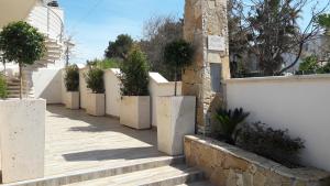 托雷圣乔万尼乌B&B Punta Stilo的一条有白色围栏和盆栽的步道