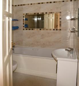 斯莱恩Townley Hall Apartments的带浴缸、盥洗盆和卫生间的浴室