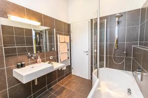 皮森多夫Emma Apartments的浴室配有水槽、淋浴和浴缸。