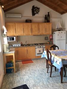 Praia do NorteAdelaide House的厨房配有桌子和白色冰箱。