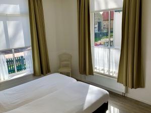 霍勒姆第一斯图瓦酒店的卧室配有白色的床和2扇窗户。