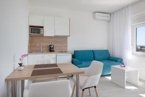 布雷拉Villa King Apartments的厨房以及带桌子和蓝色沙发的客厅。