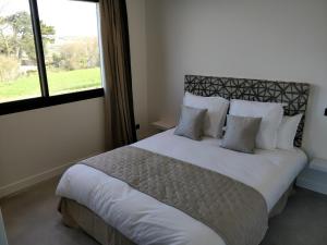 滨海瓦朗日维尔Les Gîtes du Cap Cod的卧室配有一张大白色床和窗户
