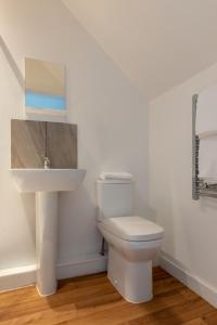 法恩伯勒Charlie Mews的浴室配有白色卫生间和盥洗盆。