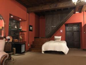 帕拉斯德丽Pazo de Laia的卧室设有红色的墙壁和一张带白色床单的床