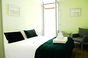 科英布拉库布拉鲁斯酒店的卧室配有一张白色大床和椅子
