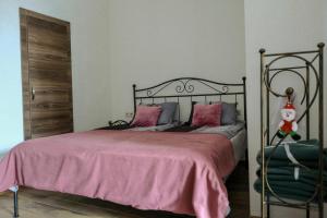 第比利斯3 Studio的一间卧室配有一张带粉红色床罩的床