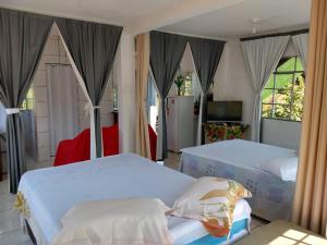 伊瓜苏特雷济尼亚度假屋的一间卧室配有两张床和电视