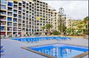 美洲海滩Vina del Mar Playa de LasAmericas, floor8 sea view的大型公寓大楼,设有大型游泳池