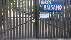 埃尔孙扎尔Hostal El Balsamo的栅栏上的标志,上面有标志
