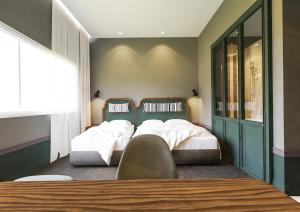 哥打京那巴鲁杰塞尔顿酒店的一间卧室设有两张床和窗户。