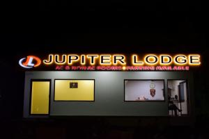 西里古里Jupiter Lodge的 ⁇ 虹灯标志的陪审员旅馆标志