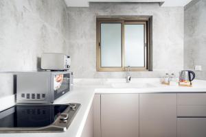 达曼TIME Dammam Residence的白色的厨房配有水槽和微波炉
