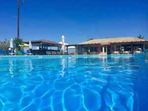 PetritíEgrypos Hotel的一座大型游泳池,其背景是一座度假村