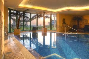 赛巴特班森波罗的海住宅班森斯特尔公寓式酒店的一座大型游泳池,位于一座带大窗户的建筑内
