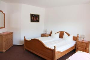 农嫩霍恩Gästehaus Reutemann的一间卧室配有木床和2个床头柜