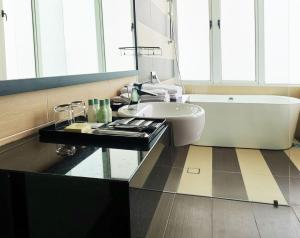 新山KSL度假酒店的浴室配有白色浴缸、盥洗盆和浴缸。