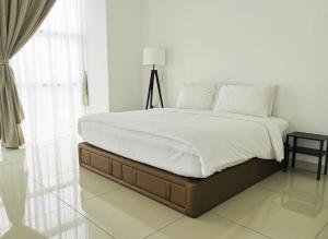 新山KSL度假酒店的一间卧室配有一张带白色床单和一盏灯的床。