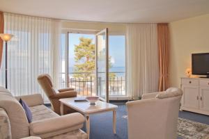 赛巴特班森波罗的海住宅班森斯特尔公寓式酒店的客厅配有沙发、椅子和电视