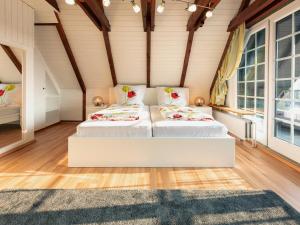 StinteckReetkate am Meer的客房内设有两张床,配有木地板和窗户。