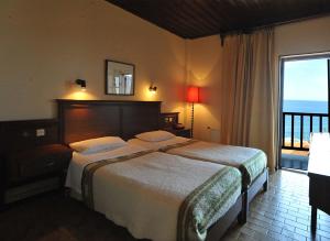 阿吉奥斯伊欧尼斯肯奇康精品酒店与简易别墅的一间卧室设有一张床,享有海景