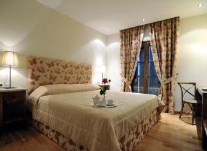 阿吉奥斯伊欧尼斯肯奇康精品酒店与简易别墅的一间卧室配有一张床和一张鲜花桌子