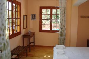 PalaiokatoúnaVilla's ground floor apartment with 60 qm swimming pool的卧室配有床、长凳和窗户。