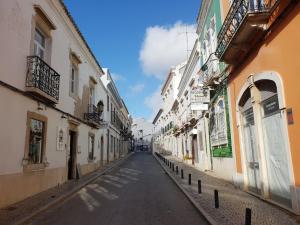 法鲁Old Charming House Faro的建筑物之间的小巷里一条空的街道