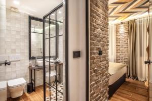 贝尔格莱德首席奢华套房公寓式酒店的一间带卫生间、水槽和砖墙的浴室