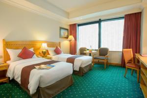 香港华大盛品酒店的酒店客房带两张床和一张桌子以及椅子。