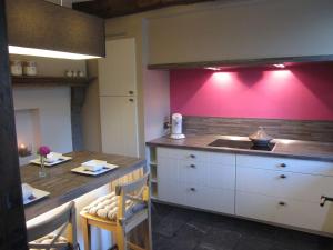 杜柏La Romaine的厨房配有桌子和粉红色的墙壁