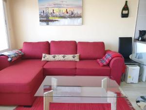 塔科龙特Cosy Well Located Apartment with swimming pool Tenerife的客厅里一张红色的沙发,配有玻璃桌