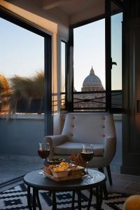 罗马特里亚诺公寓酒店的一张桌子,上面放着一盘食物和两杯葡萄酒