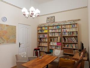 布达佩斯Sakuranbo - Guest House的用餐室配有桌子和书架,书架上装满了书籍