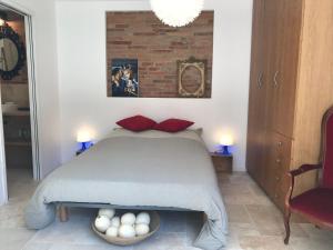 图卢兹La bulle de Gaston的一间卧室配有一张带红色枕头的床和砖墙