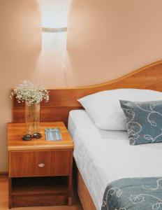 杜布罗夫尼克伊夫卡酒店的一间卧室设有两张床和一张花瓶桌子。