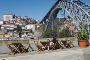 加亚新城Porto View by Patio 25的坐在桥前桌子上的女人