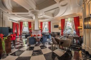 巴塞罗那巴塞罗那中心酒店的酒店大堂设有桌椅和红色窗帘