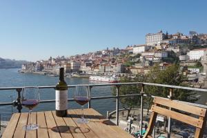 加亚新城Porto View by Patio 25的一张桌子上放着一瓶葡萄酒,放上两杯