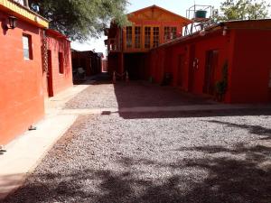 圣佩德罗·德·阿塔卡马Hostal Las Kañas的一个空洞的、有红色建筑和砾石的小巷