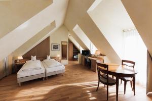 海德堡海德堡考特布拉奥雷酒店的一间卧室配有一张床、一张桌子和一张桌子