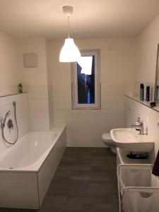 莱茵豪森Fewo Dani的白色的浴室设有浴缸和水槽。