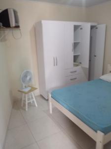 弗洛里亚诺波利斯Pousada Residencial Caroa的一间卧室配有一张床、一张桌子和一把椅子