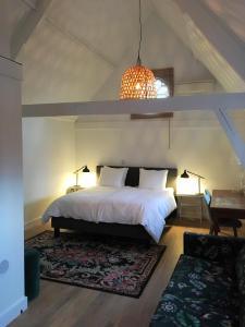 蒂尔堡NineT7的卧室配有一张白色的大床和一张桌子