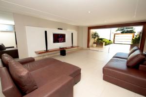 纳塔尔维阿卡斯特拉瓦如汽车旅馆（仅接待成人）的客厅配有棕色真皮沙发和电视